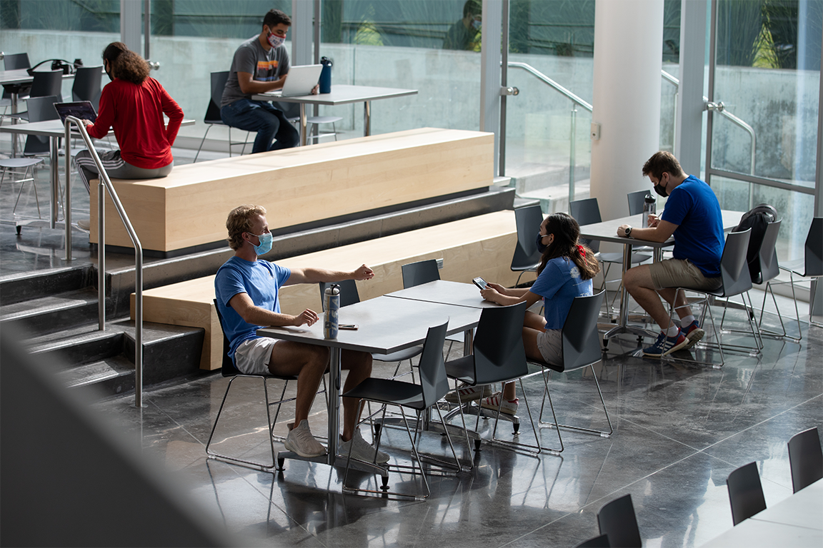 Students working at tables wearing masks.